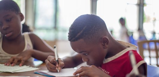 Cursos Online: Aprenda no seu próprio ritmo boy writing on printer paper near girl